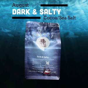 A bag of coffee labeled 'August Dark & Salty Cocoa/Sea Salt' is centered over an underwater ocean scene. The package is blue-gray with white text and a small boat graphic near the bottom.