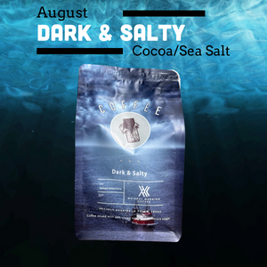 A bag of coffee labeled 'August Dark & Salty Cocoa/Sea Salt' is centered over an underwater ocean scene. The package is blue-gray with white text and a small boat graphic near the bottom.